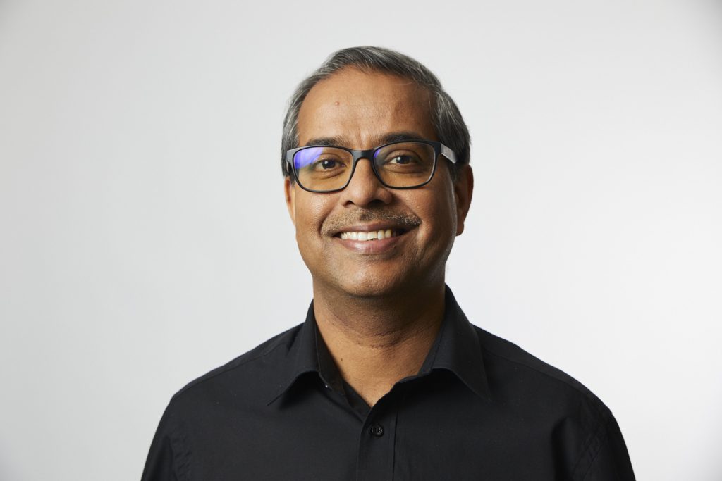 Vivek Singh of IKEA Foundation. He is wearing a black shirt and is smiling.
